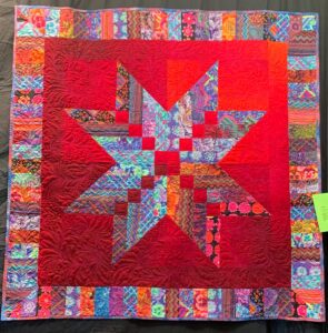 Bright red quilt with pieced lone star center