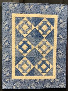 small blue and white churn dash quilt hand quilted