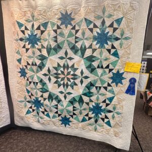 Quilt in teals, taupe and blue with explodng star appearance